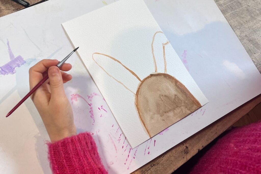 "Kinder lernen durch Malen - Kind malt einen Hasen mit Aquarellfarben"