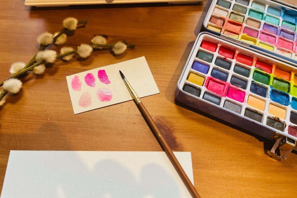 Kinder lernen durch Malen - kreativer Arbeitsplatz mit Aquarellfarben, Pinsel und Papier