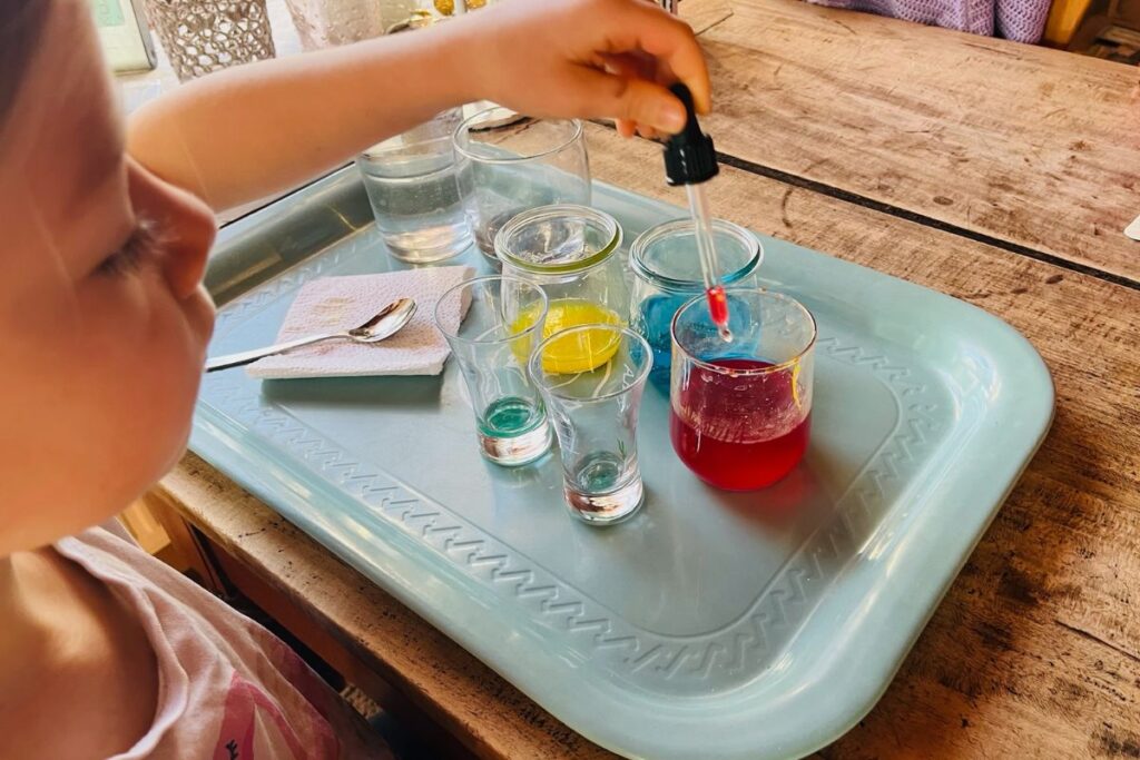Kind experimentiert mit Farben und Wasser - freies Lernen im Alltag