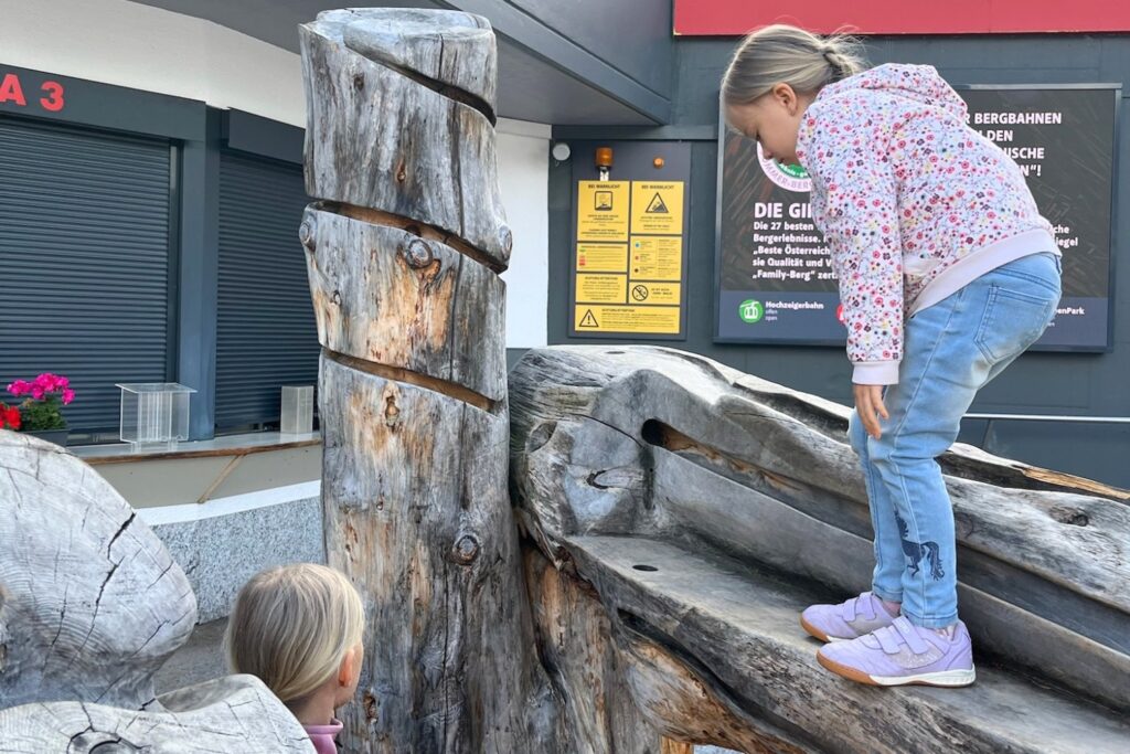 Kinder spielen an der Holzkugelbahn im ZirbenPark Hochzeiger im Pitztal.