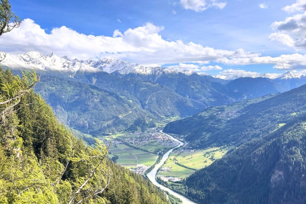 Aussicht vom Gachenblick am Naturparkhaus Kaunergrat über das Kaunertal mit schneebedeckten Bergen und Fluss.
