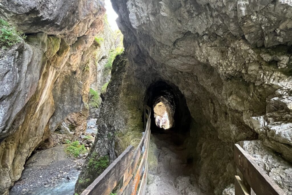 Felstunnel in der Rosengartenschlucht bei Imst mit Holzsteg zwischen steilen Felswänden – ein besonderes Naturerlebnis für Familien in Tirol.